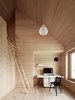 Spruce wood also lines the floor, walls, and ceiling in the bedrooms. The residents must climb a ladder to access the loft above. Photo 2 of Sven Matt's Simple Gabled Home modern home