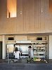 Modern home with Kitchen, Stone Counter, Pendant Lighting, Refrigerator, Range, Range Hood, and Undermount Sink. The kitchen island is topped with PaperStone in slate and wrapped in the same steel used to clad the house’s facade. “We matched the color to create a ‘2001: Space Odyssey’ monolith,” Garlick says. Photo 7 of Sky House