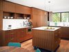Modern home with Kitchen, Dark Hardwood Floor, Wood Cabinet, Marble Counter, and Pendant Lighting. A movable island, set on stainless steel casters, sits in the center of the kitchen. The Panasonic microwave is built into the cabinetry and the August pendant lights illuminating the island are by Uberhaus. Photo of The Dwell Guide to Kitchen Design