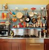 Modern home with Kitchen and Cooktops. Vintage kettles and a wide-ranging assortment of pots and pans sit above kitchen cabinets from IKEA. Photo of The Dwell Guide to Kitchen Design