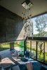 A chandelier hangs over the high ceiling in the living room. The deck outside is made from ipe and the living room flooring is by Interceramic. Photo 3 of A Home Rocks Out with Natural Stone, Concrete, and a Volcano modern home