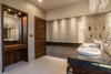 The spacious bathroom features wood paneling and Hansgrohe fixtures. The sink and toilet are from Villeroy & Boch. Photo 5 of A Home Rocks Out with Natural Stone, Concrete, and a Volcano modern home