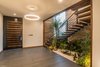 Local plants are abundant inside and out. Natural light and ventilation were key elements when designing the home. The result includes this interior courtyards that connects the house with the landscape by bringing it inside. Photo 6 of A Home Rocks Out with Natural Stone, Concrete, and a Volcano modern home