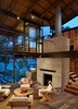 Modern home with Living Room, Wood Burning Fireplace, and Standard Layout Fireplace. The owners’ main living area has two stories with a master bedroom, which can be accessed by a rolling door, and porches on either end of the structure. “This large, barn-like building, with its moveable bedroom wall and office, allows the house to be both intimate and social, effortlessly accommodating guests or individuals alike,” Flato says. Photo 5 of Hog Pen Creek