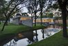 Privacy was important to the family, but they also wanted large expanses of glass through which to enjoy the trees and pond. The solution was a clever C-shaped courtyard plan that shields the home's open interior. Photo 7 of Preston Hollow modern home