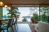 Modern home with Living Room, Pendant Lighting, and Chair. Three 28.1 Single Mini pendant lights by Bocci hang above a dining table that was custom-built by the owner and her father. Bikappa dining chairs by Kristalia mirror the clean lines of the vintage chair in the living room. Photo 4 of San Juan Islands Residence