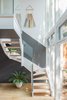 The back staircase abuts a glass facade overlooking the backyard and allowing plenty of light into the kitchen area above. The art hanging on the wall is by artist Julie Thevenot. Photo 5 of Color Splash modern home