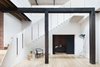 “To draw light and ventilation into what was a poorly oriented and deep footprint, an extensive number of operable skylights were introduced on the north- and south-facing roof pitches, and a large void connecting the floors was strategically positioned to also take advantage of this amenity,” Simpson says. American oak floorboards and Dulux paint were used throughout the property for continuity. Photo 2 of Water Factory modern home