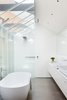 “A critical aspect of the project was the incorporation of natural light and ventilation within a broad footprint,” Simpson says. Conventionally private areas, like bedrooms and bathrooms, are therefore reinterpreted with more openness in mind. For instance, this bathroom’s skylights mirror those found throughout the rest of the property. The bathtub, basins, and showerhead were all purchased at the Australian retailer Reece. Photo 8 of Water Factory modern home