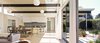 The 2,500-square-foot house has an open-plan living, dining, and kitchen area. Criss Cross Ball pendant lamps by George Nelson cover the ceiling. The kitchen features Sub-Zero and Wolf appliances and a backsplash of Heath tile. Photo of If Eichler Designed a House Today, This Is What It Might Look Like modern home