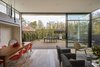 Modern home with Living Room, Chair, Sofa, and Medium Hardwood Floor. From the start of the project, a tangible connection to the rear garden was at the top of the clients’ wish list. This fluid transition from the living room is enhanced by ceiling height steel framed double-glazed sliders. Clerestory windows bring additional light in, and enhance the feeling of openness. Photo of Just Redo It: A Home Near Melbourne Takes Another Stab at a Dated '80s Addition