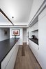 Modern home with Kitchen, Cooktops, White Cabinet, Medium Hardwood Floor, and Refrigerator. The streamlined kitchen features Miele cooktop, Sirius hood, Siemens oven, and Fisher & Paykel refrigerator. Photo of Just Redo It: A Home Near Melbourne Takes Another Stab at a Dated '80s Addition