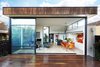Modern home with Outdoor, Large Patio, Porch, Deck, and Wood Patio, Porch, Deck. The dramatic rear elevation showcases the open-plan living and dining room. Apart from the addition, the rest of the home maintained its “traditional” layout, with bedrooms branching off from a central hallway. Windows on all sides of the addition bring light in and make the space feel bright and expansive. Tonal and textural contrast can be seen between the burnt ash cladding at the exterior and the engineered European oak flooring at the interior. Through thoughtful design and space planning, the architects and owners made the biggest impact possible with only 500 square feet of added living space. Photo of Just Redo It: A Home Near Melbourne Takes Another Stab at a Dated '80s Addition