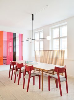 Dining Room, Table, Chair, Pendant Lighting, Ceiling Lighting, and Light Hardwood Floor In the dining area of the kitchen, a Mobile Chandelier 3 by Michael Anastassiades is suspended above a table from local cabinetmaker Københavns Møbelsnedkeri. Vintage red dining chairs by Ralf Lindberg mingle with an Ilse Crawford bench for De La Espada. Photos courtesy the Apartment.