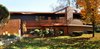 Western Red Cedar panels wrap around the exterior of the house. The main entry is clad in Tongue and Groove cedar panels. Photo of A Couple Reclaims Bowling Alley Floors for Their Family's Bedrooms and Even Saves Some for a Custom Bench modern home