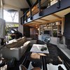 A loft floor looks over the living room which in contrast to the slate flagstone, uses steel plate flooring. Photo of A Couple Reclaims Bowling Alley Floors for Their Family's Bedrooms and Even Saves Some for a Custom Bench modern home
