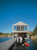 Modern home with Exterior, House, Boathouse Building Type, and Wood Siding Material. Cedar slats help this Ontario lake house float soundly atop still waters. Photo by: Raimund Koch Photo of Stunning Waterfront Structures