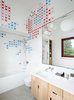 Modern home with Bath Room, Drop In Sink, Alcove Tub, Corner Shower, Wall Lighting, Ceramic Tile Wall, and One Piece Toilet. Husband-and-wife ceramic artists, Dear Human, baked x-shaped decals into store-bought Olympia Tile before arranging them in the kids’ bathroom. The tub is by Bette and the sink, set in a Corian countertop, is by Duravit. Photo of 50+ Modern Tile Ideas for Walls, Floors and Ceilings