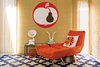 Modern home with Living Room, Chair, and Rug Floor. “I want everything to have a sense of place,” says Adler. “To me Shelter Island is a rustic, relaxed place.” Oatmeal grass cloth wallpaper, a Talitha rug, and Whitaker chair and ottoman, all by Adler, and vintage artwork instill the interior with a comfortable retro quality. Photo of How to Design with Orange