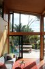 The double-height addition exaggerates the home's actual size and augments its views, bringing the total footprint to 1,400 square feet. Bedrooms and other key spaces are spread out around the new living room. Photo of A Little Kiwi Beach House Beefs Up Big Time modern home