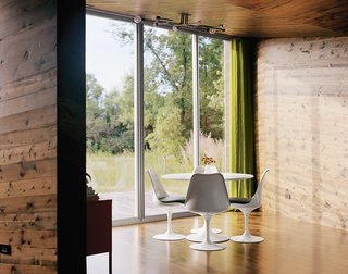 A Saarinen dining table and Tulip chairs for Knoll sit in the front of the living/dining room, with a wide view to the prairie on the other side of the house.