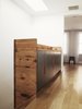 On the top floor, the bookshelf becomes a storage cabinet at the entry to the master bedroom. A well-placed skylight illuminates the staircase. Photo of It's Back to Basics for This 1901 Brooklyn Town House modern home