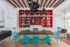A quartet of red paints (Raspberry Truffle, Million Dollar Red, Vermillion, Arroyo Red), all by Benjamin Moore, make the built-in shelving in the dining area pop. The table is a custom design made of bookmatched walnut slabs joined by lacquered butterflies. The chairs are vintage Paul McCobb lacquered in turquoise (Benjamin Moore's Aruba Blue). The Ligne Roset Ruché sofa, designed by Inga Sempé, separates the living and dining spaces. The chandelier is by David Weeks Studio. Photo of Material Focus: Custom Walnut Designs modern home