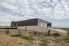 Pine was used for the exterior siding and the lower perimeter base is lined in reinforced concrete. Photo of Unplugged modern home