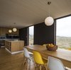 Eames DSW Molded Fiberglass chairs surround the dining table made of local wood and constructed by the owners. Photo 8 of Unplugged modern home