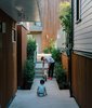 Modern home with Outdoor, Small Patio, Porch, Deck, and Concrete Patio, Porch, Deck. Resident Misha Bukowski plays with young Zachary in the walkway between the renovated buildings. The new units are clad in stained local cedar. Photo of Modern Spaces in the Pacific Northwest