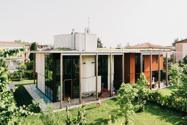 Studiopietropoli created two houses on one site, each with fluid connections to the surrounding garden. A green roof creates a portico between them.