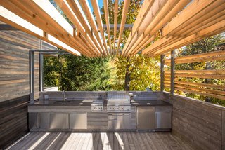 At one end of the L-shaped terrace, interior designer Martine Brisson included room for a full outdoor kitchen so the family could prepare meals without stepping inside during the warmer months.