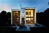 Modern home with Exterior, Wood Siding Material, House, and Glass Siding Material. Where once there was a timeworn 1950s bungalow in the Metropolitan Green Belt south of London, there now stands a dynamic house whose two volumes are joined by a glass atrium. The project was designed by Grant Freeman of OB Architecture. Photo of Wrap House