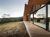 Modern home with House Building Type, Outdoor, Wood Siding Material, Large Patio, Porch, Deck, Wood Patio, Porch, Deck, and Slope. Constructing a largely timber house in a bush fire-prone landscape wasn’t easy. “We had to negotiate with the council and building surveyor,” Crump explains. To solve the challenge, the architect designed an outer, protective skin for the home that’s clad with metal; it pushes beyond the building envelope to provide covering for outdoor living spaces. The inset walls are lined with local shiplap Celery Top Pine. Photo 2 of Lookout House