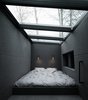 Modern home with Bedroom. A Velux skylight above the sleeping loft includes remote-controlled integrated blinds. The prefab unit can sleep up to four people between the bed loft and the lower-level daybed. Photo of Prefab Gets a Makeover With Danish Industrial Design