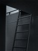 An adjustable ladder, which blends in with the walls in Vipp's signature ebony powder-coated steel, leads up to the sleeping loft. Photo of Prefab Gets a Makeover With Danish Industrial Design modern home