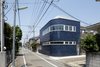 The blue porcelain tiles covering the house’s exterior are typical of commercial buildings of earlier decades. “It was intended to invoke nostalgia of the past and newness at the same time,” lead architect Akio Nakasa says. Photo of Half & Half House modern home