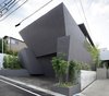 Concrete planters frame the facade—a union of monolithic slabs that offers privacy and compositional integrity to the building. The exterior is a plaster finish over insulation and concrete. Photo of SRK modern home