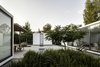 Modern home with Outdoor, Concrete Patio, Porch, Deck, Back Yard, Trees, and Large Patio, Porch, Deck. One of the biggest challenges of the project was keeping the open courtyard cool enough for the residents to enjoy it. The architects used a low impact water feature to create ambient cooling and two native flamboyant trees to provide shade. Photo of A Minimalist Mexican Retreat that Uses an Array of Strategies to Beat the Heat