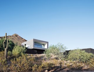 A lone saguaro marks the southwest corner of Thomas and Laura Hyland’s property, which is situated adjacent to the Phoenix Mountain Preserve. The structure’s main living volume is elevated and faced in glass, overlooking a descending pathway that leads to a pool tucked into the site.