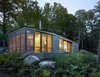 Modern home with Exterior, Cabin Building Type, House Building Type, and Wood Siding Material. Sited on a lake near Bracebridge, Ontario, this small-footprint family cottage was designed by Toronto firm superkül to integrate with its natural surroundings and minimize its environmental impact. The clients, a married couple, had mixed feelings about going completely modern with their cabin's aesthetic, so the architects created a sculptural wood form to bridge the gap between traditional and contemporary. Photo by Shai Gil. Photo of Stealth Cabin