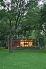 Modern home with Exterior, House, and Prefab Building Type. In a family’s pint-size lake retreat in Austin, Texas, ipe siding and decking meet concrete floors and steeland-glass windows. Stained cyprus was used for the ceiling and soffit. The custom barn-style sliding door conceals the family’s collection of giant inner tubes and other boating equipment. Photo by: Kimberly Davis Photo of Simple American Getaways