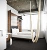 Modern home with Bedroom, Bed, Pendant Lighting, and Carpet Floor. There are no closets and no minibars in the guest rooms, reflecting the designers' minimalist approach. Features include a curved wooden headboard and a hammock hanging from the ceiling. Unfinished ceilings reveal partitions of the old structure, even down to the screws. Photo of Hotel Daniel