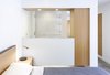 The option of having an extra bedroom for their growing family was an attractive one for Scholz and Preskill as they looked to expand the living area of their cozy home. In doing so, they found themselves “cramming a full program into not that much space,” says Scholz. To achieve this, and still maintain a sense of fluidity and openness, the new master bedroom and bathroom were designed as a nontraditional open-concept space, without a continuous dividing wall between them. The light, airy bedroom features a custom LW bed and wall-hung side tables, both by San Francisco-based OHIO Design, along with a steel-and-white-oak lamp by Rich Brilliant & Willing. Photo of KS Mission modern home