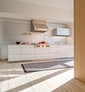 To transform a gaudy and green developer's special, Nanelda Priftaj, an in-house designer at Bulthaup Toronto, stuck to a sophisticated palette of light woods and stainless-steel appliances. "We chose materials that elevate the aesthetic timelessness and comfort of the space," she says. "Keeping this in mind, we chose several reflective surfaces to brighten the kitchen." The floors are heated Mare Argento travertine and the rug is from AGATHOM Co.