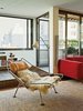 Modern home with Living Room, Chair, Shelves, Floor Lighting, and Sofa. A Flag Halyard chair by Hans Wegner in long-haired sheepskin occupies one end of the living room. Photo of 17 Modern Homes With Hans Wegner Furniture