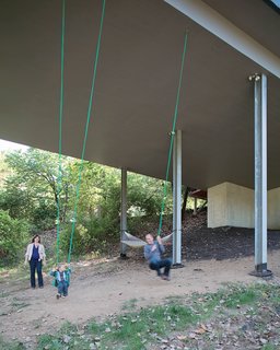 Julie, James, and Christian enjoy an unexpected bonus of living in a house on stilts that has a pair of swings suspended from the base of the structure. The family often goes for walks on the property, looking for wildlife and playing in the tepee they built in a secluded space in the woods.