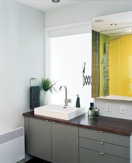 Tiles from Ramacieri-Soligo brighten the bathroom, off the hall. But when it comes to modern bathroom vanities, gray, as seen here, is a popular choice. 