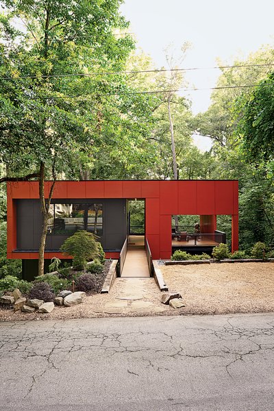 A bridge spans the home’s steep site for street access.