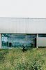 Modern home with Exterior, House Building Type, and Metal Siding Material. The front entrance of the Farley Studio presents a clean, minimalist space—a stark contrast to the colorful clutter of the painting studio hidden behind corrugated-metal walls at the back of the house. Photo of Steel Yourself